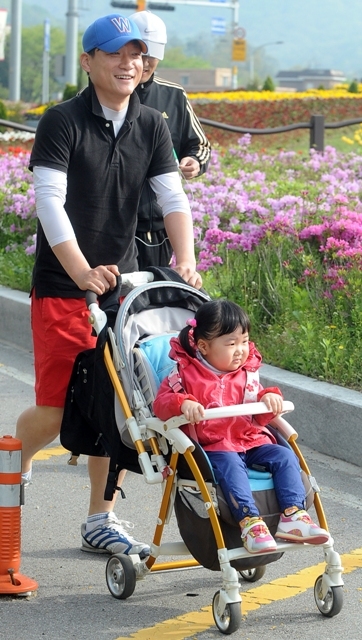한 참가자가 어린 자녀가 탄 유모차를 끌고 달리고 있다. 특별 취재반