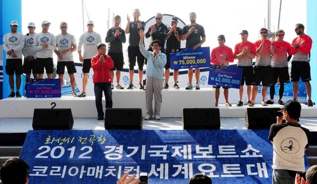 화성시 전곡항과 안산시 탄도항 일대에서 열린 ‘2012 경기국제보트쇼 및 코리아매치컵 세계요트대회’가 3일 폐막됐다. 폐막식 시상식에 참석한 김문수 경기지사가 코리아매치컵 요트대회에서 1위를 차지한 스웨덴의 비욘 한센팀, 2위 영국의 이안 윌리엄스팀, 3위 뉴질랜드의 필 로버트슨 에게 상패와 상금을 전달한 후 함께 손을 들어 축하해 주고 있다. 전형민기자 hmjeon@kyeonggi.com