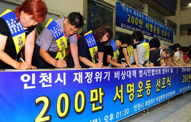 28일 인천시 재정위기 극복을 위한 인천시 재정위기 비상대책 범시민협의회 발족식 및 200만 서명운동 선포식 행사가 열린 인천시청에서 참가 시민들이 아시안게임 정부 지원을 촉구하는 서명을 하고 있다. 장용준기자 jyjun@kyeonggi.com