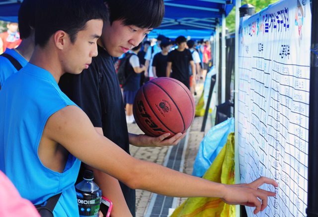 11일 과천 관문체육관에서 2012 과천 토리배 3on3 길거리 농구대회 개막식 행사를 마친 참가 선수들이 코트앞 게시판에서 경기시간을 확인하고 있다. 장용준기자 jyjun@kyeonggi.com