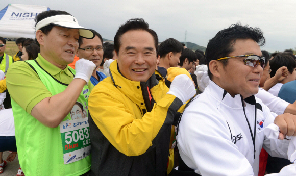 2012안산 바닷길 환경마라톤대회에서 김철민 안산시장과 임창열 경기일보 대표이사 회장 등이 서로 안마를 해주고 있다.