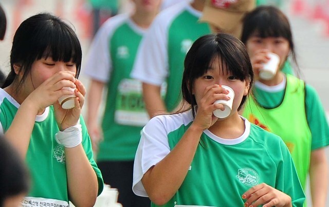 10Km 코스 참가한 여학생들이 첫번째 급수대 앞에서 앞다퉈 물을 마시며 갈증을 달래고 있다 장용준 기자 jyjun68@kyeonggi.com
