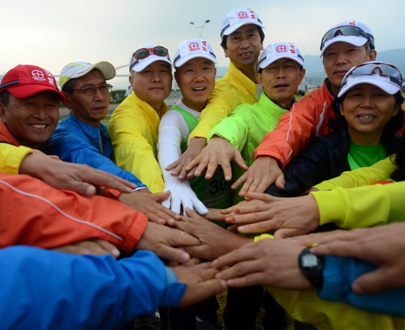 2012 구리 코스모스 마라톤 대회가 열린 14일 구리 한강시민공원에서 단체 참가자들이 손을 모아 파이팅을 외치고 있다. 추상철기자 scchoo@kyeonggi.com
