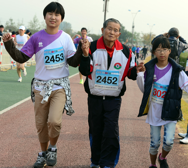2012 구리 코스모스 마라톤대회가 열린 14일 구리 한강시민공원에서 한 어르신 참가자가 손주의 손을 잡고 결승점을 통과하고 있다. 추상철기자 scchoo@kyeonggi.com