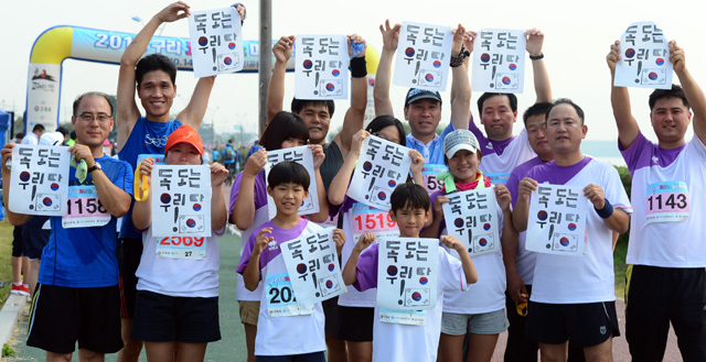 2012 구리 코스모스 마라톤대회가 열린 14일 구리 한강시민공원에서 한 단체 참가자들이 '독도는 우리땅' 문구를 들어 보이고 있다. 추상철기자 scchoo@kyeonggi.com
