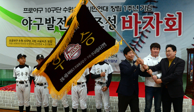 프로야구 10구단 수원유치 시민연대 창립 1주년 기념 야구발전기금조성 바자회가 열린 11일 수원 종합운동장에서 염태영 수원시장이 우승기 봉납식 후 우승기를 흔들고 있다. 추상철기자 scchoo@kyeonggi.com