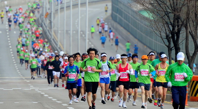 14일 제11회 경기마라톤에 참가한 하프코스 선수들이 일원삼거리 지점에서 1차 반환지점을 향해 힘찬 발걸음을 디딛고 있다. 특별취재반