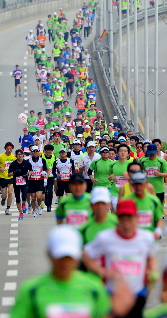 14일 제11회 경기마라톤에 참가한 하프코스 선수들이 일원삼거리 지점에서 1차 반환지점을 향해 힘찬 발걸음을 디딛고 있다. 특별취재반