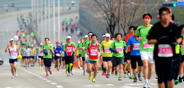 14일 제11회 경기마라톤에 참가한 하프코스 선수들이 일원삼거리 지점에서 1차 반환지점을 향해 힘찬 발걸음을 디딛고 있다. 특별취재반
