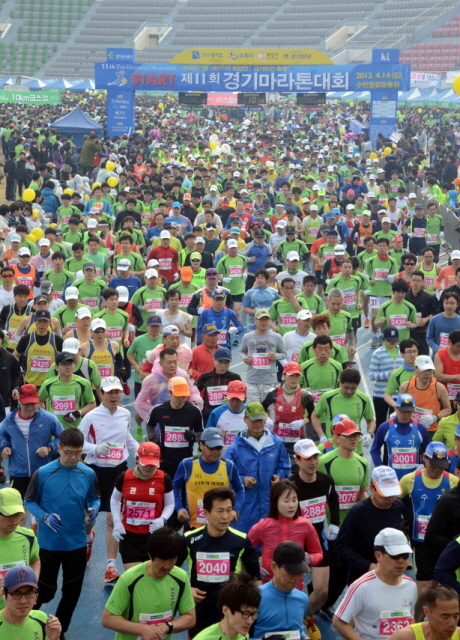 14일 수원 종합운동장에서 열린 제11회 경기마라톤대회에서 각 부문 참가자들이 출발 총성과 함께 힘차게 출발 하고 있다. 이날 대회에는 풀코스, 하프코스, 10KM, 5KM 부문에 2만여 명의 마라토너와 가족들이 참여했다. 특별취재반