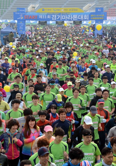 14일 수원 종합운동장에서 열린 제11회 경기마라톤대회에서 각 부문 참가자들이 출발 총성과 함께 힘차게 출발 하고 있다. 이날 대회에는 풀코스, 하프코스, 10KM, 5KM 부문에 2만여 명의 마라토너와 가족들이 참여했다. 특별취재반