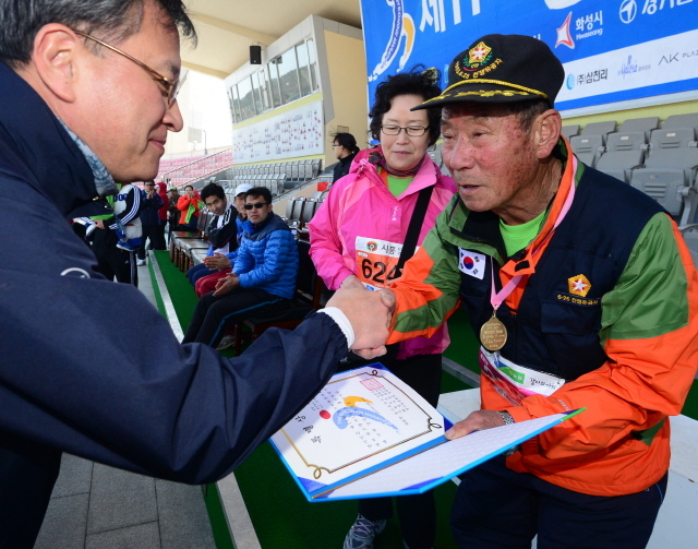 경기일보가 주최한 제11회 경기마라톤대회가 열린 14일 수원 종합운동장에서 경기일보 이승규 전무이사가 최고령 참가자에게 상장을 수여하고 있다. 특별취재반