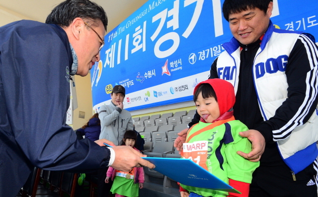 경기일보가 주최한 제11회 경기마라톤대회가 열린 14일 수원 종합운동장에서 경기일보 이승규 전무이사가 최연소 참가자에게 상장을 수여하고 있다. 특별취재반