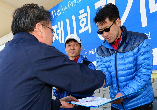 경기일보가 주최한 제11회 경기마라톤대회가 열린 14일 수원 종합운동장에서 경기일보 이승규 전무이사가 남자 5km부문 입상자에게 상장을 수여하고 있다. 특별취재반