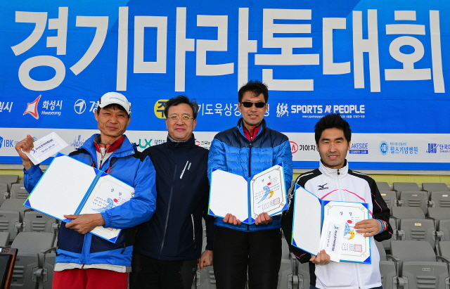 경기일보가 주최한 제11회 경기마라톤대회가 열린 14일 수원 종합운동장에서 경기일보 이승규 전무이사가 남자 5km부문 입상자와 함께 기념촬영을 하고 있다. 특별취재반
