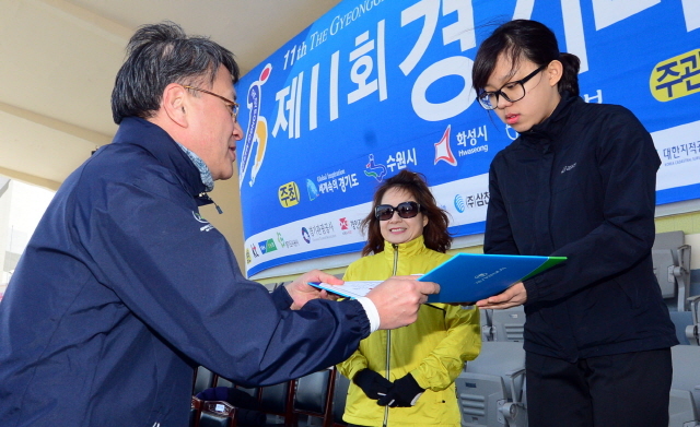 경기일보가 주최한 제11회 경기마라톤대회가 열린 14일 수원 종합운동장에서 경기일보 이승규 전무이사가 여자 5km부문 입상자에게 상장을 수여하고 있다. 특별취재반