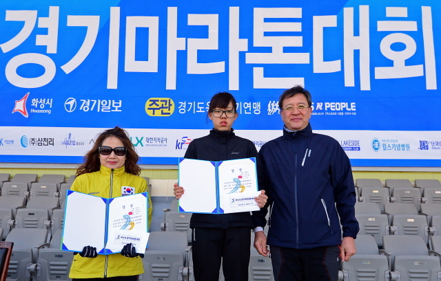 경기일보가 주최한 제11회 경기마라톤대회가 열린 14일 수원 종합운동장에서 경기일보 이승규 전무이사가 여자 5km부문 입상자들과 함께 기념촬영을 하고 있다. 특별취재반
