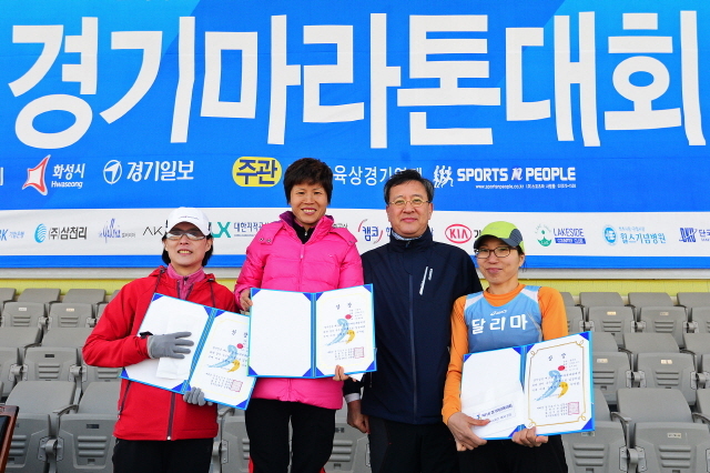 경기일보가 주최한 제11회 경기마라톤대회가 열린 14일 수원 종합운동장에서 경기일보 이승규 전무이사가 여자 10km부문 수상자에게 상장을 수여한 후 기념촬영을 하고 있다. 특별취재반