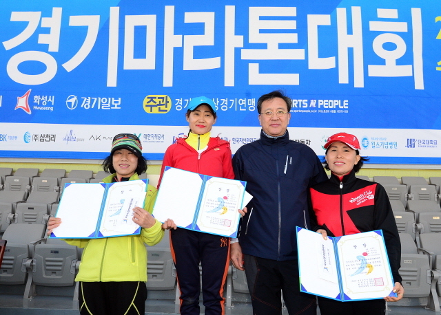 경기일보가 주최한 제11회 경기마라톤대회가 열린 14일 수원 종합운동장에서 경기일보 이승규 전무이사가 여자 하프부문 입상자들과 함께 기념촬영을 하고 있다. 특별취재반