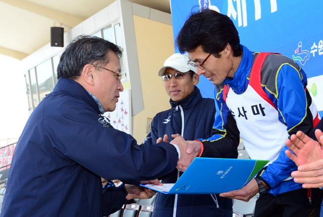 경기일보가 주최한 제11회 경기마라톤대회가 열린 14일 수원 종합운동장에서 경기일보 이승규 전무이사가 남자 하프부문 입상자에게 상장을 전달하고 있다. 특별취재반