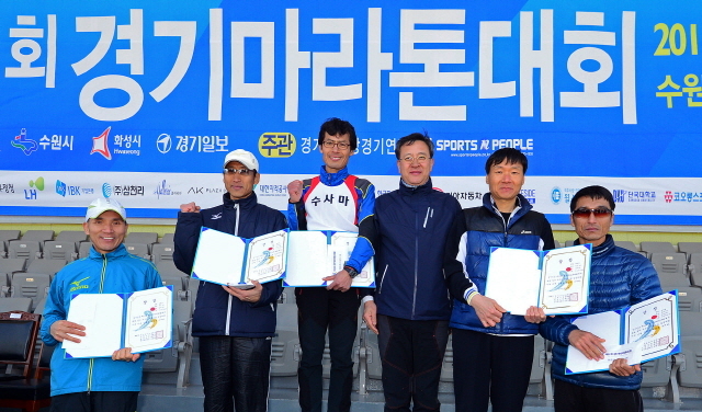 경기일보가 주최한 제11회 경기마라톤대회가 열린 14일 수원 종합운동장에서 경기일보 이승규 전무이사가 남자 하프부문 입상자들과 함께 기념촬영을 하고 있다. 특별취재반