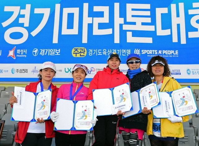 경기일보가 주최한 제11회 경기마라톤대회가 열린 14일 수원 종합운동장에서 여자 풀코스 입상자들이 기념촬영을 하고 있다. 특별취재반
