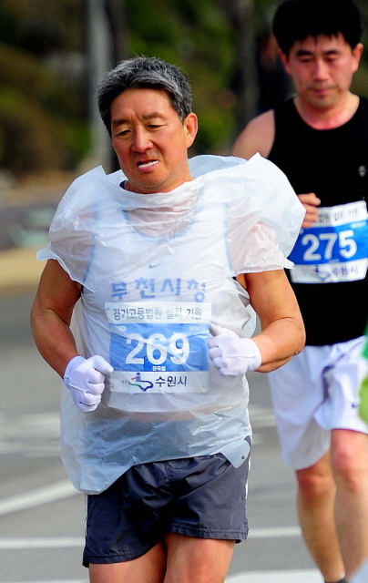 14일 제11회 경기마라톤 풀코스의 한 참가 선수가 쌀쌀한 날씨를 의식한듯 대형 비닐봉투를 임시 방편으로 착용한 채 전력을 다해 질주하고 있다. 특별취재반