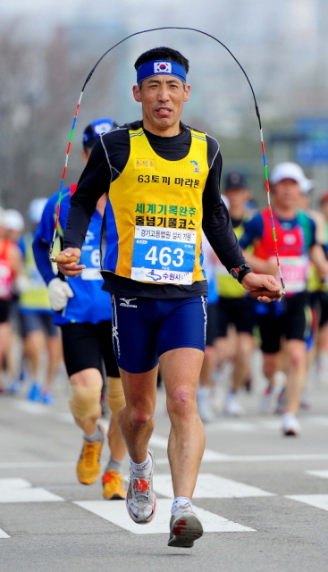 14일 제11회 경기마라톤 풀코스에 참가한 한 선수가 줄넘기를 하며 반환지점을 향해 달려가고 있다. 특별취재반