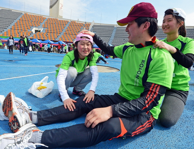 경기일보가 주최한 제11회 경기마라톤대회가 열린 14일 수원 종합운동장에서 가족단위 참가자가 서로 안마를 해주며 즐거워 하고 있다. 특별취재반