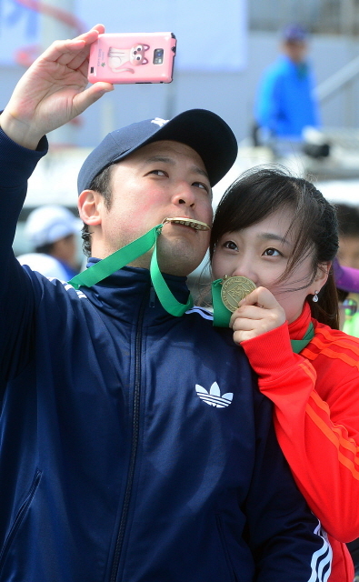 경기일보가 주최한 제11회 경기마라톤대회가 열린 14일 수원 종합운동장에서 연인이 함께 참가한 참가자들이 완주메달을 목에 걸고 기념촬영을 하고 있다. 특별취재반