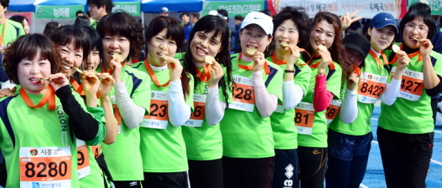 14일 수원종합운동장에서 열린 제11회 경기마라톤대회에 참가한 한 직장동료로 구성된아줌마 부대가 5km를 완주후 기념메달을 깨물며 자랑스러워 하고 있다. 특별취재반