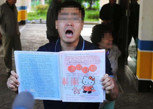 25일 오후 인천 모자 살인사건 피의자의 부인 김모씨가 경찰 출석을 앞두고 자살한 인천시 남동구 논현동 자택에서 김씨의 오빠가 공범의 억울함을 호소하며 유서를 취재진에게 공개하고 있다. 장용준기자 jyjun@kyeonggi.com