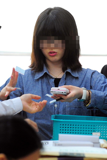2014학년도 대학수학능력시험이 실시된 7일 인천시 연수구 인천여고 고사장의 한 수험생이 핸드폰을 반납하고 있다.장용준기자 jyjun@kyeonggi.com