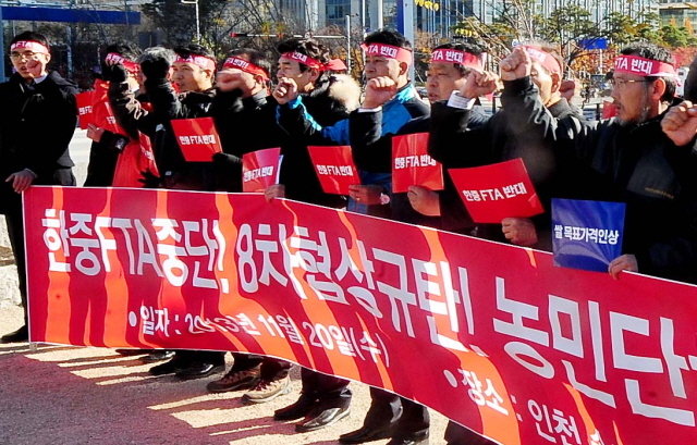 20일 오전 한·중 자유무역협정(FTA) 중단 농축산비상대책위 회원들이 협상장인 인천시 연수구 송도국제도시내 쉐라톤호텔 앞에서 한·중 FTA 반대 기자회견을 하고 있다.장용준기자 jyjun@kyeonggi.com
