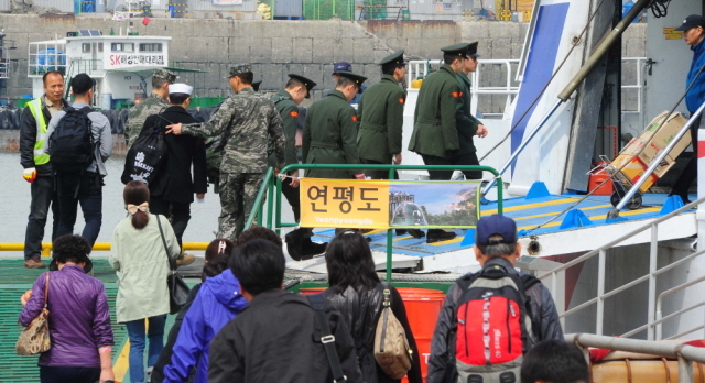 북한이 서해 북방한계선(NLL) 인근 해상에 해상사격을 실시한 31일 인천시 중구 연안여객터미널에서 주민들과 연평부대 장병들이 인천∼연평 항로의 유일한 여객선인 플라잉 카페리호로 승선하고 있다. 한편, 플라잉 카페리호는 공교롭게 출항시각이 북한의 사격시간과 겹치면서 운항통제가 발효돼 인천항을 출발하지 못했다.장용준기자 jyjun@kyeonggi.com