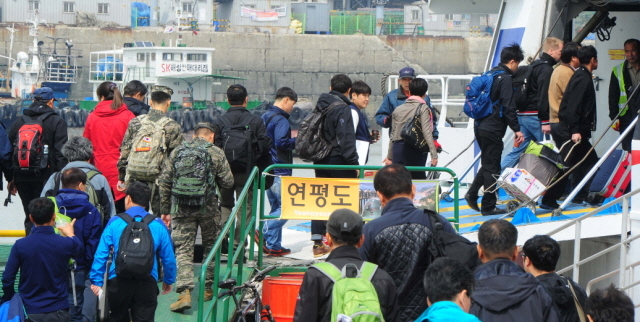 북한이 서해 북방한계선(NLL) 인근 해상에 해상사격을 실시한 31일 인천시 중구 연안여객터미널에서 주민들과 연평부대 장병들이 인천∼연평 항로의 유일한 여객선인 플라잉 카페리호로 승선하고 있다. 한편, 플라잉 카페리호는 공교롭게 출항시각이 북한의 사격시간과 겹치면서 운항통제가 발효돼 인천항을 출발하지 못했다.장용준기자 jyjun@kyeonggi.com