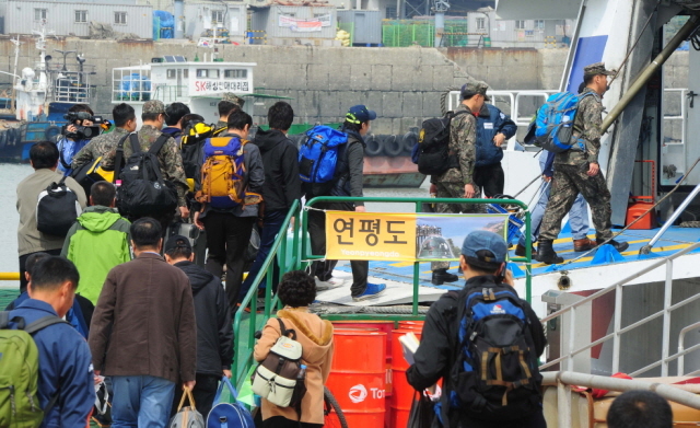 북한이 서해 북방한계선(NLL) 인근 해상에 해상사격을 실시한 31일 인천시 중구 연안여객터미널에서 주민들과 연평부대 장병들이 인천∼연평 항로의 유일한 여객선인 플라잉 카페리호로 승선하고 있다. 한편, 플라잉 카페리호는 공교롭게 출항시각이 북한의 사격시간과 겹치면서 운항통제가 발효돼 인천항을 출발하지 못했다.장용준기자 jyjun@kyeonggi.com