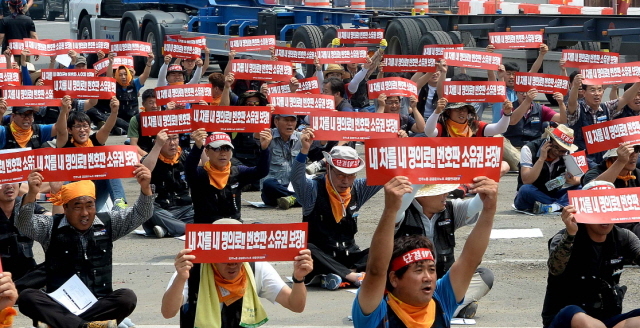 14일 오전 일일 파업에 돌입한 민주노총 공공운수노조 화물연대 인천지부 회원들이 인천시 중구 항동 화물연대 노동자 쉼터 광장에서 지입제도 개선을 비롯한 5대 요구사항을 요구하는 구호를 외치고 있다.장용준기자 jyjun@kyeonggi.com