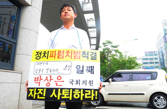 7일 오전 정치 자금법 위반 등의 혐의를 검찰조사를 받기 위해 새누리당 박상은(인천 중구·동구·옹진군) 국회의원이 인천지검에 출두한 시각에 박의원의 전 비서인 장관훈씨가  지검 정문 앞에서 자진사퇴를 요구하는 1인 시위를 하고 있다. 장용준기자 jyjun68@kyeonggi.com