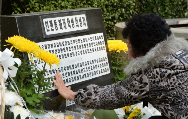 30일 오전 인천시 중구 학생문화회관에서 열린 '인천 인현동 화재사고 15주기 추모식'에서 한 유족이 희생 학생들의 추모비를 어루만지며 슬퍼하고 있다. 장용준기자