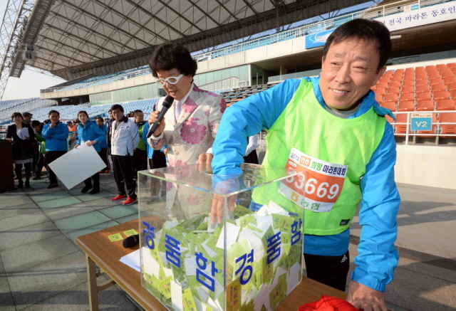 9일 안산시와 경기일보가 공동 주최한 ‘2014 안산 희망 마라톤대회’에서 제종길 안산시장이 행운권 추첨을 하고 있다.전형민기자