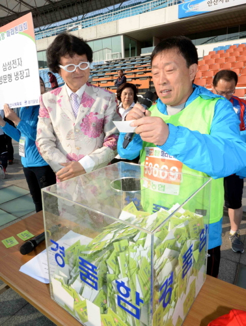 9일 안산시와 경기일보가 공동 주최한 ‘2014 안산 희망 마라톤대회’에서 제종길 안산시장이 행운권 추첨을 하고 있다.전형민기자