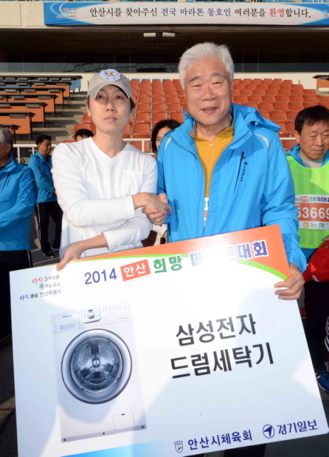 9일 안산시와 경기일보가 공동 주최한 ‘2014 안산 희망 마라톤대회’에서 이순국 경기일보 사장 이 행운권 시상을 하고 있다.전형민기자