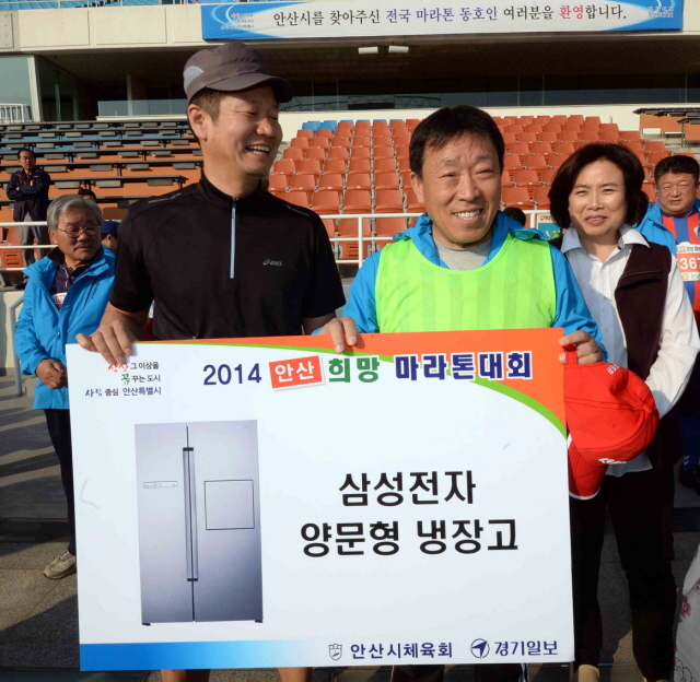 9일 안산시와 경기일보가 공동 주최한 ‘2014 안산 희망 마라톤대회’에서 제종길 안산시장이 행운권 시상을 하고 있다.전형민기자