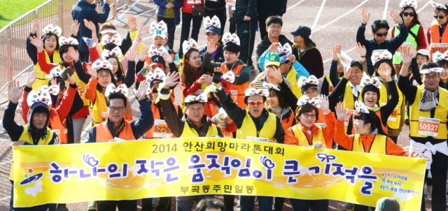 9일 안산시와 경기일보가 공동 주최한 ‘2014 안산 희망 마라톤대회’에 참가한 안산 부곡동 주민들이 “하나의 작은 움직임이 큰기적을 이룬다”는  희망의 메세지가 담긴 현수막을 들고 와스타디움을 힘차게 출발하고 있다.전형민기자