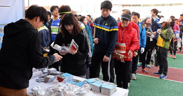 안산시와 경기일보가 공동주최한 2014 안산 희망 마라톤대회가 열린 9일 안산 와스타디움에서 안산시 홍보부스에서 길게 줄선 참가자들이 각종 기념품을 받고 있다. 추상철기자