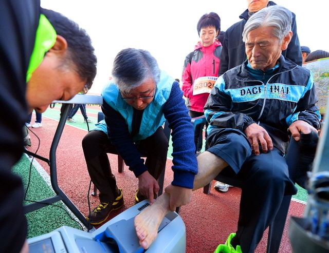 안산시와 경기일보가 공동주최한 2014 안산 희망 마라톤대회가 열린 9일 안산 와스타디움에서 참가자들이 건강체험 부스에 마련된 골밀도 검사를 받고 있다. 추상철기자