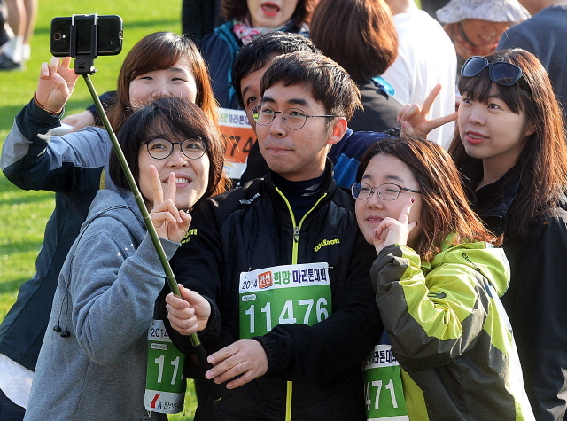 안산시와 경기일보가 공동주최한 2014 안산 희망 마라톤대회가 열린 9일 안산 와스타디움에서 참가자들이 출발전 셀카봉을 이용해 기념촬영을 하고 있다. 추상철기자