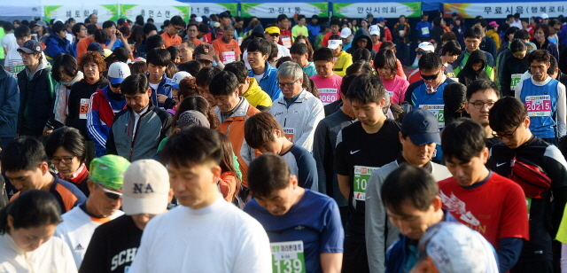 안산시와 경기일보가 공동주최한 2014 안산 희망 마라톤대회가 열린 9일 안산 와스타디움에서 참가자들이 출발전 세월호 희생자를 위한 묵념을 하고 있다. 추상철기자