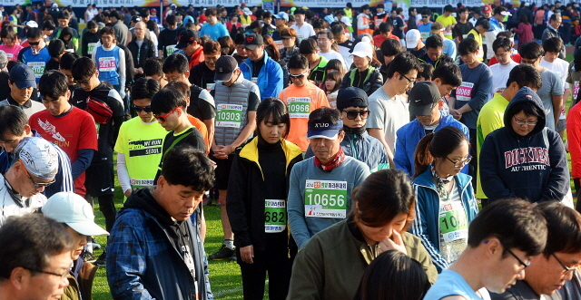 안산시와 경기일보가 공동주최한 2014 안산 희망 마라톤대회가 열린 9일 안산 와스타디움에서 참가자들이 출발전 세월호 희생자를 위한 묵념을 하고 있다. 추상철기자